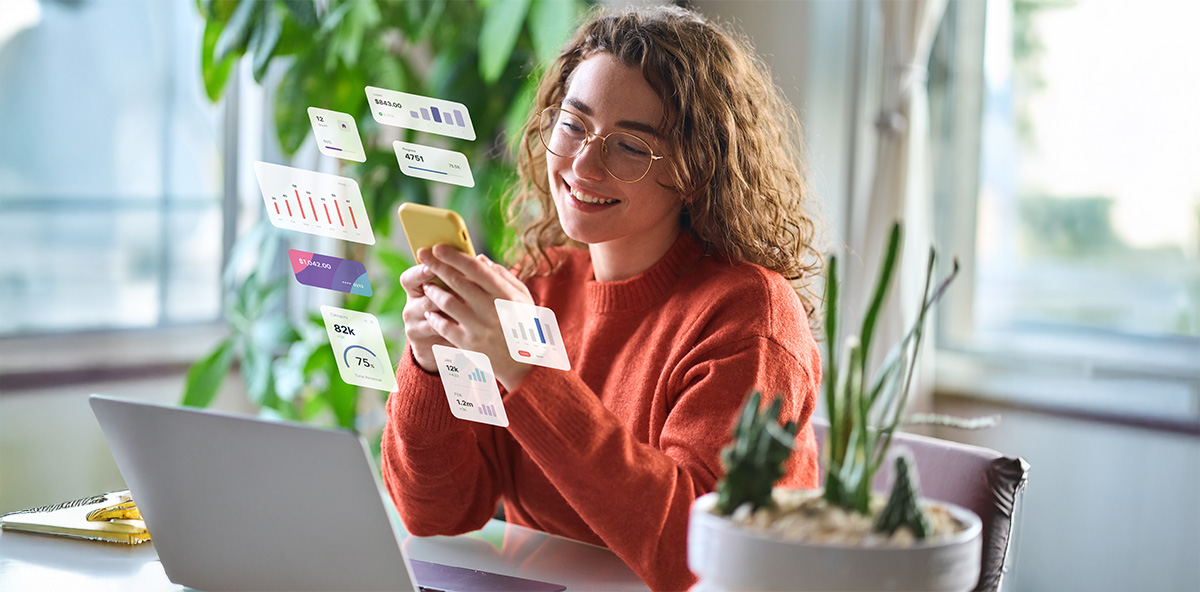 Woman analyzing Partner Marketing data on phone with digital charts floating around.