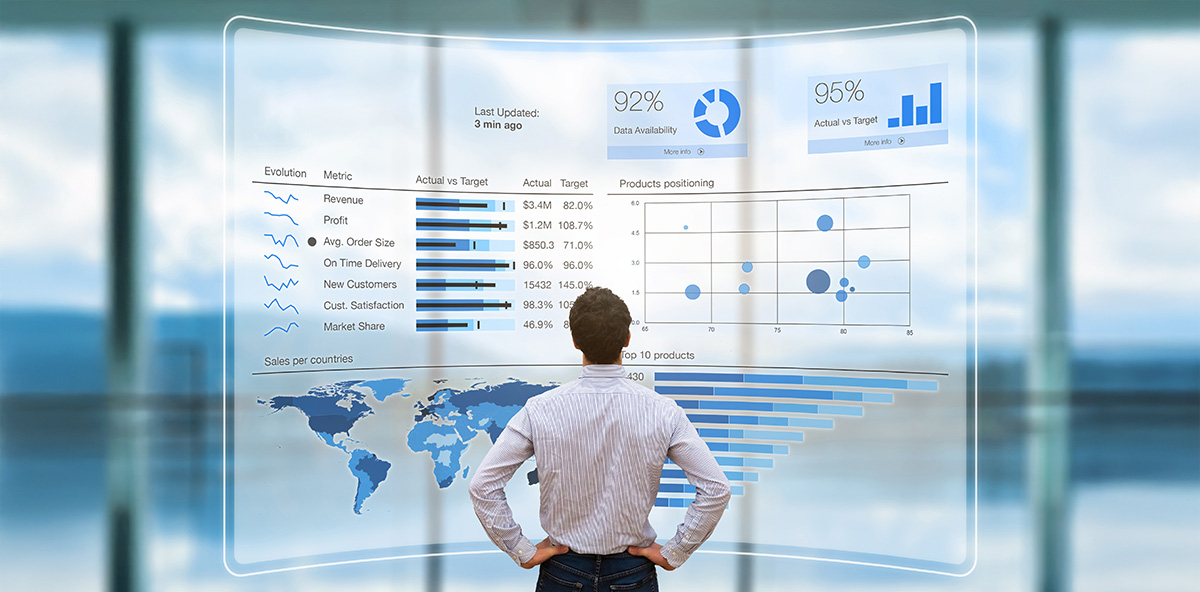A person analyzing a futuristic digital dashboard displaying business metrics, data charts, and global sales performance for strategic decision-making.