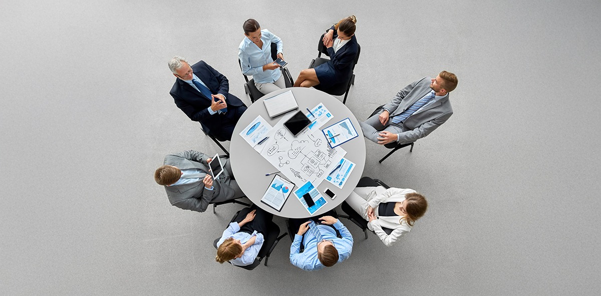 Business team discussing strategy around a table, illustrating the 90-day leadership playbook in partner marketing.