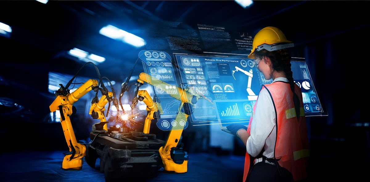 Engineer using holographic interface to control robotic arms in an Industry 4.0 setup.