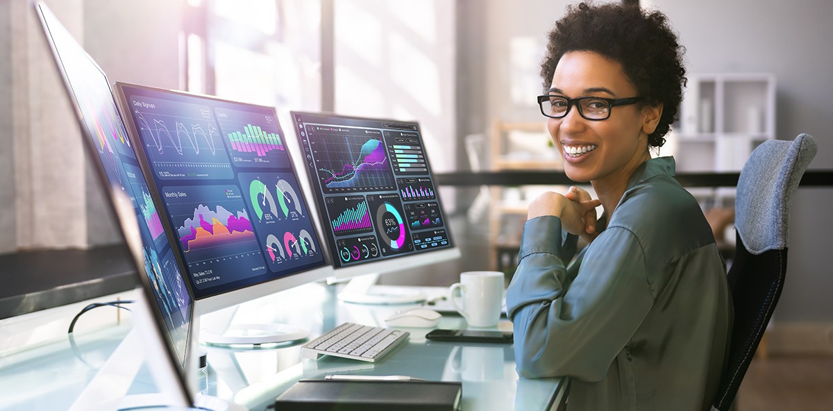 Professional analyzing PartnerOps dashboards with data charts on multiple monitors.